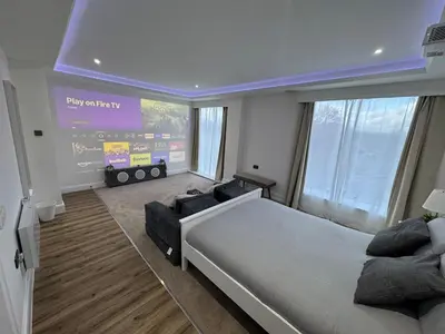 a bedroom with a large bed and a large screen at Cinema room apartment 2 in Basildon