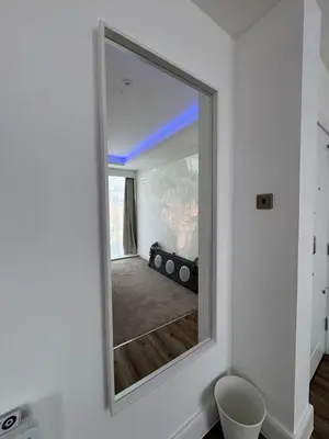 a mirror on a wall in a room at Cinema room apartment 2 in Basildon