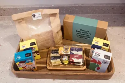 a wooden tray with a box and a bag of food at Little Dunton Lodges 1 in Little Burstead