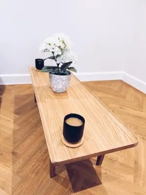 a wooden coffee table with a vase of flowers on it at Little Dunton Lodges 1 in Little Burstead