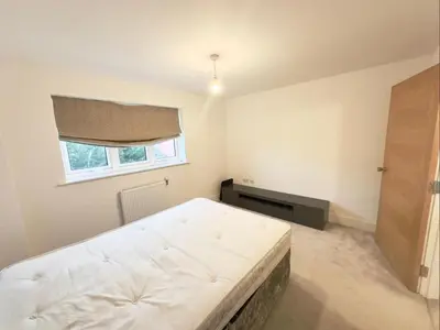 a bedroom with a white bed and a window at Spacious 6-Bed Detached Home in Chigwell in Friern Barnet