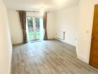 an empty living room with a door and curtains at Spacious 6-Bed Detached Home in Chigwell in Friern Barnet