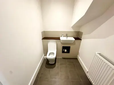 a bathroom with a toilet and a sink at Spacious 6-Bed Detached Home in Chigwell in Friern Barnet