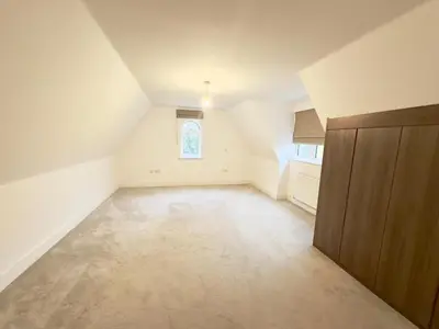 an empty attic room with a door and a window at Spacious 6-Bed Detached Home in Chigwell in Friern Barnet