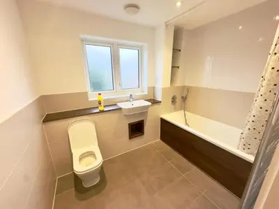 a bathroom with a toilet and a sink and a bath tub at Spacious 6-Bed Detached Home in Chigwell in Friern Barnet