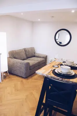 a living room with a table and a couch at Little Dunton Lodges 2 in Brentwood