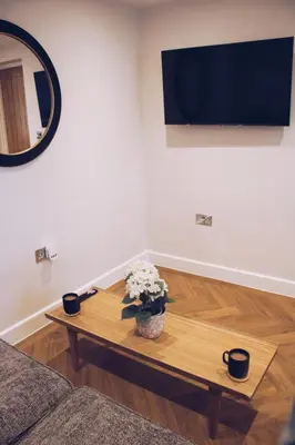 a living room with a coffee table and a tv at Little Dunton Lodges 2 in Brentwood