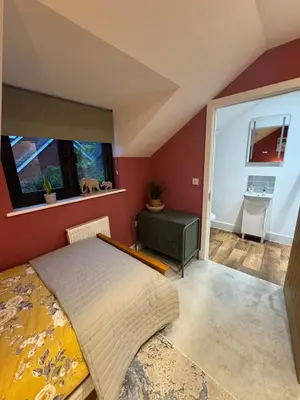 a bedroom with red walls and a bed and a window at Kim's Place in Hingham