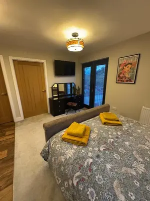 a bedroom with a bed with two yellow towels on it at Kim's Place in Hingham
