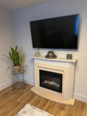 a living room with a fireplace with a flat screen tv at Kim's Place in Hingham