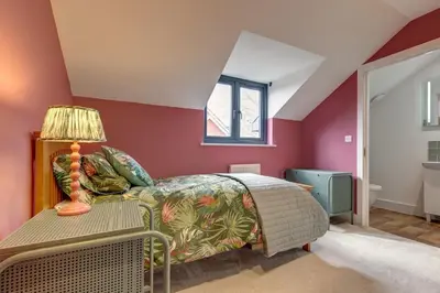 a bedroom with a bed and a table with a lamp at Kim's Place in Hingham