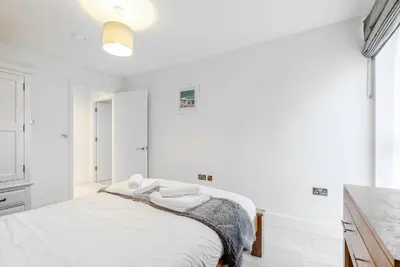 a white bedroom with a bed with towels on it at Tailored Stays - Central Station Apartments in Cambridge
