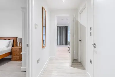 a hallway leading to a bedroom with white walls at Tailored Stays - Central Station Apartments in Cambridge