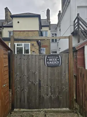 a wooden fence with a sign on top of it at Coastal Comfort in Leigh Ideal for Work & Leisure in Southend-on-Sea