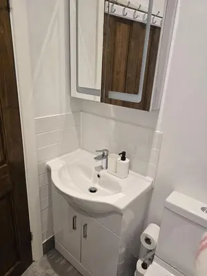 a white bathroom with a sink and a mirror at Coastal Comfort in Leigh Ideal for Work & Leisure in Southend-on-Sea