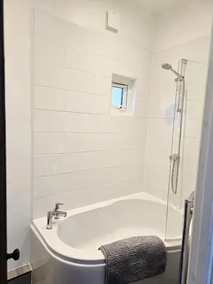 a white bathroom with a tub and a shower at Coastal Comfort in Leigh Ideal for Work & Leisure in Southend-on-Sea