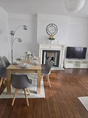 a dining room with a table and chairs and a fireplace at Coastal Comfort in Leigh Ideal for Work & Leisure in Southend-on-Sea
