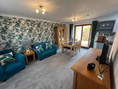 a living room with blue couches and a table at Charming 1BR Cottage in Aldringham in Aldringham