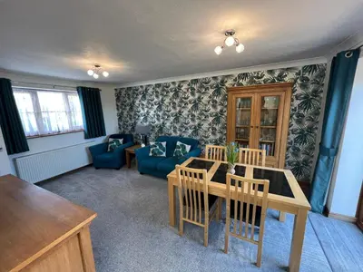 a living room with a table and a blue couch at Charming 1BR Cottage in Aldringham in Aldringham