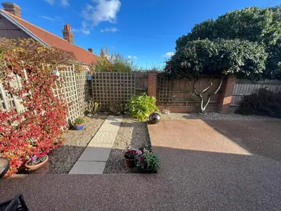 a garden with potted plants in front of a fence at Charming 1BR Cottage in Aldringham in Aldringham