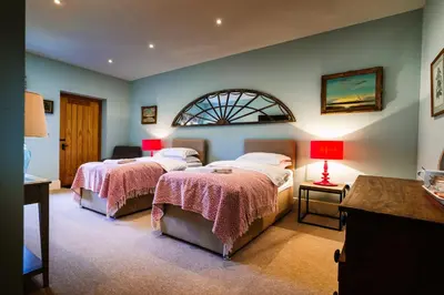 a bedroom with two beds and a window at Chippenham Park Garden Rooms in Chippenham