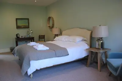 a bedroom with a large bed with towels on it at Chippenham Park Garden Rooms in Chippenham