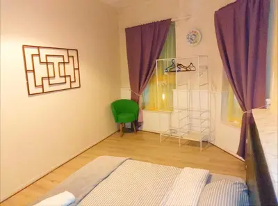 a bedroom with a bed and a green chair at Home stay central in Cambridge
