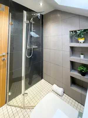 a shower with a glass door in a bathroom at Easy walk to Addenbrookes - Stylish 1 bedroom Apartment in CBG