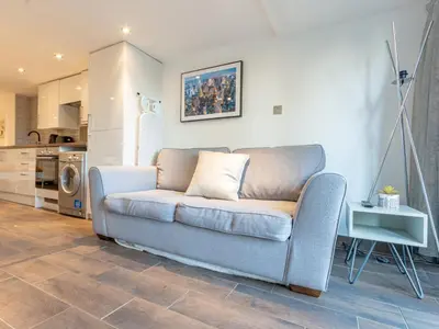 a living room with a couch and a kitchen at Pass the Keys Cosy Studio in Basildon Sleeps up to 4 in Basildon
