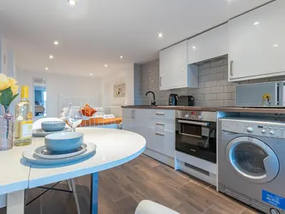 a kitchen with a table and a washing machine at Pass the Keys Cosy Studio in Basildon Sleeps up to 4 in Basildon