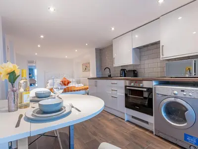a kitchen with a table and a washing machine at Pass the Keys Cosy Studio in Basildon Sleeps up to 4 in Basildon