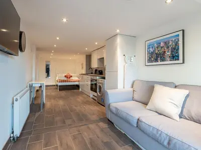 a living room with a couch and a kitchen at Pass the Keys Cosy Studio in Basildon Sleeps up to 4 in Basildon