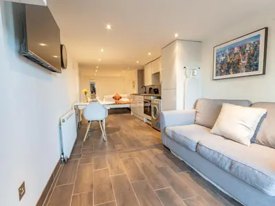 a living room with a couch and a kitchen at Pass the Keys Cosy Studio in Basildon Sleeps up to 4 in Basildon