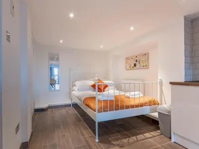 a bedroom with a bed with an orange blanket at Pass the Keys Cosy Studio in Basildon Sleeps up to 4 in Basildon