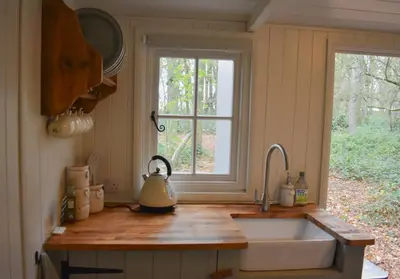 a kitchen counter with a sink and a window at Shepherd Hut in the woods