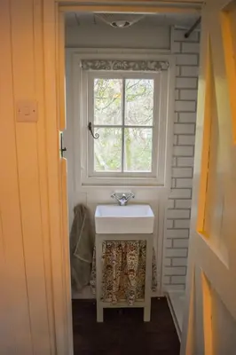 a bathroom with a sink and a window at Shepherd Hut in the woods