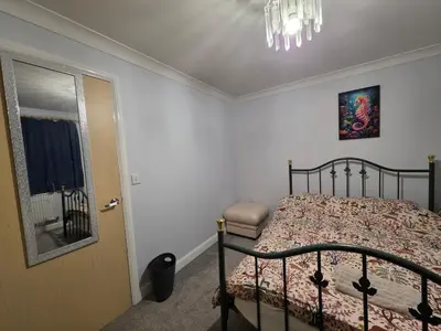 a bedroom with a bed and a mirror and a door at Home away from city noise Be in Hythe