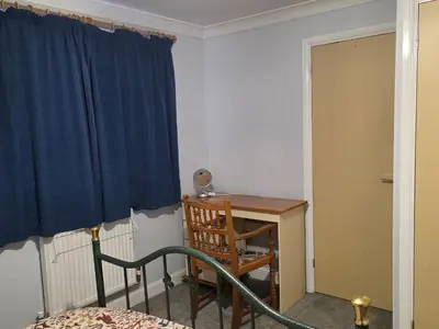 a room with a desk and a blue curtain at Home away from city noise Be in Hythe