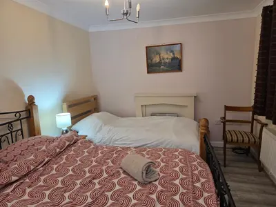 a bedroom with a bed in a room with a fireplace at Essex Colchester Cosy Room Zi in Hythe