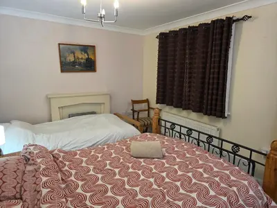 a bedroom with two beds and a window with a bedspread at Essex Colchester Cosy Room Zi in Hythe