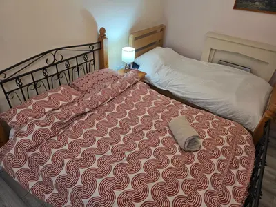 a bed with a red and white comforter in a bedroom at Essex Colchester Cosy Room Zi in Hythe