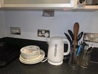 a counter top with a coffee pot and plates and utensils at Essex Colchester Cosy Room Zi in Hythe