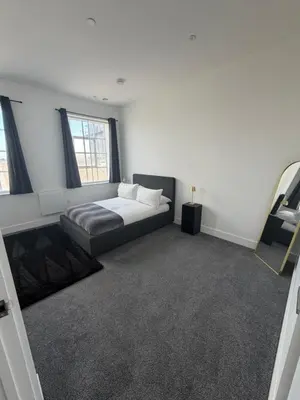 a bedroom with a bed and a couch in it at Cosy one bedroom flat in the heart of Chelmsford in Chelmsford
