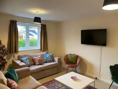 a living room with a couch and a tv at Warm & Cosy 4 Bed Cambridge House w Parking Garden & High Speed WIFI in Milton