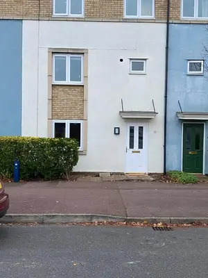 a white house with a green door on a street at Warm & Cosy 4 Bed Cambridge House w Parking Garden & High Speed WIFI in Milton