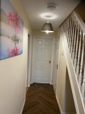 a hallway with a white door and a painting on the wall at Warm & Cosy 4 Bed Cambridge House w Parking Garden & High Speed WIFI in Milton