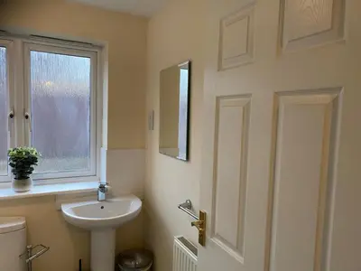a bathroom with a sink and a toilet and a window at Warm & Cosy 4 Bed Cambridge House w Parking Garden & High Speed WIFI in Milton