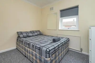 a bedroom with a bed in a room with a window at Serene 5BR - A Cozy Home Away From Home in Theydon Bois