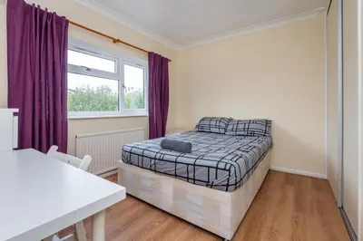a bedroom with a bed and a window at Serene 5BR - A Cozy Home Away From Home in Theydon Bois