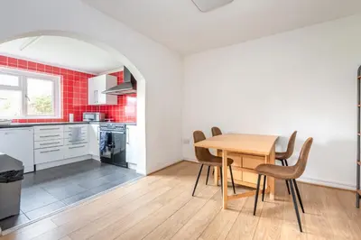 a kitchen and dining room with a wooden table and chairs at Serene 5BR - A Cozy Home Away From Home in Theydon Bois